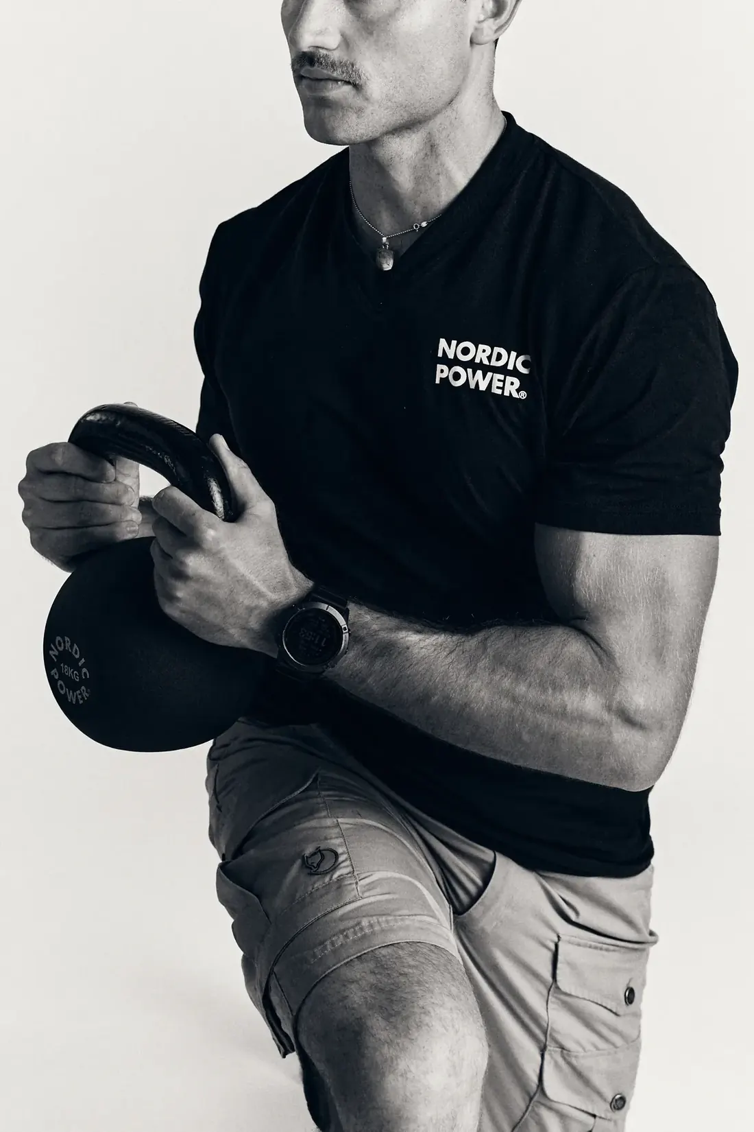 Mand træner med kettlebell, sort-hvid studiefoto