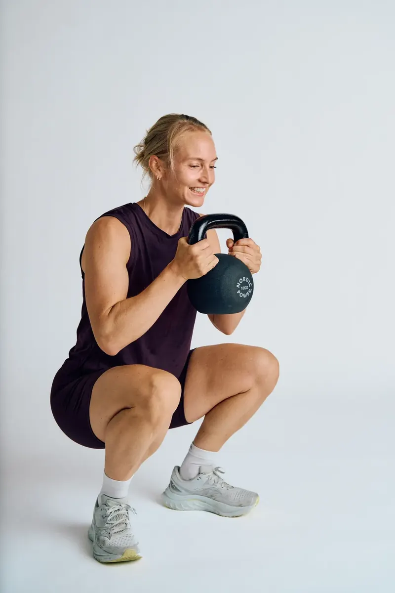 Kvinde laver goblet squat med kettlebell