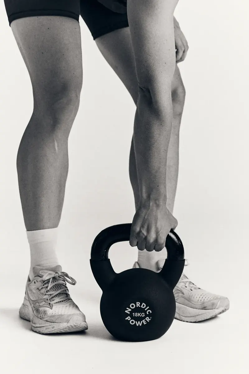 Kettlebell løftes fra gulvet mellem benene