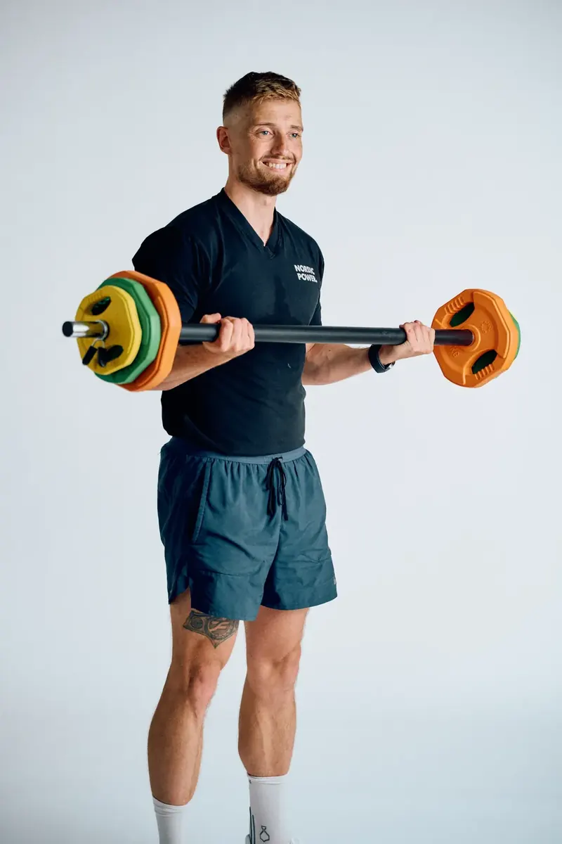 Mand laver bicepscurl med vægtstang